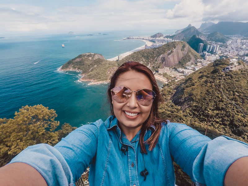 Selfie no Pão de Açúcar, com a praia vermelha e o mar azul do Rio de fundo.