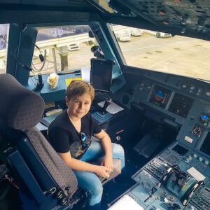 Henry na cabine do piloto do avião da Latam.